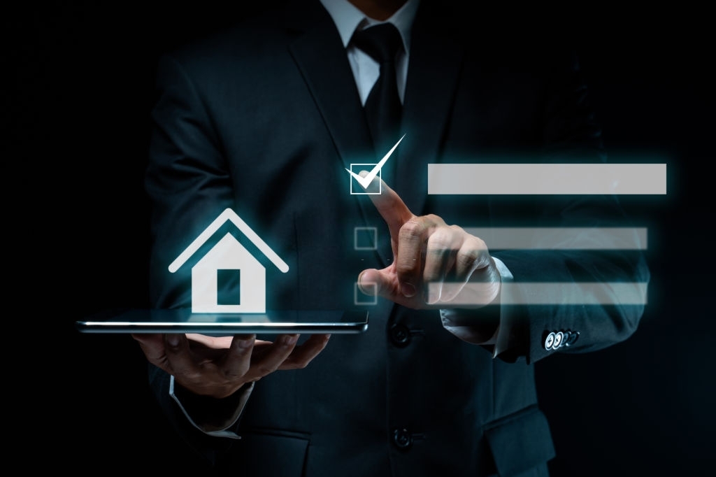 Businessman using tablet planning with home icon hologram effect.